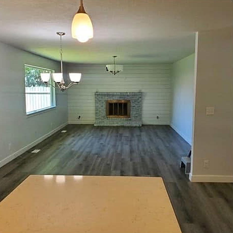 Living room after remodel with bright walls and wood-look flooring