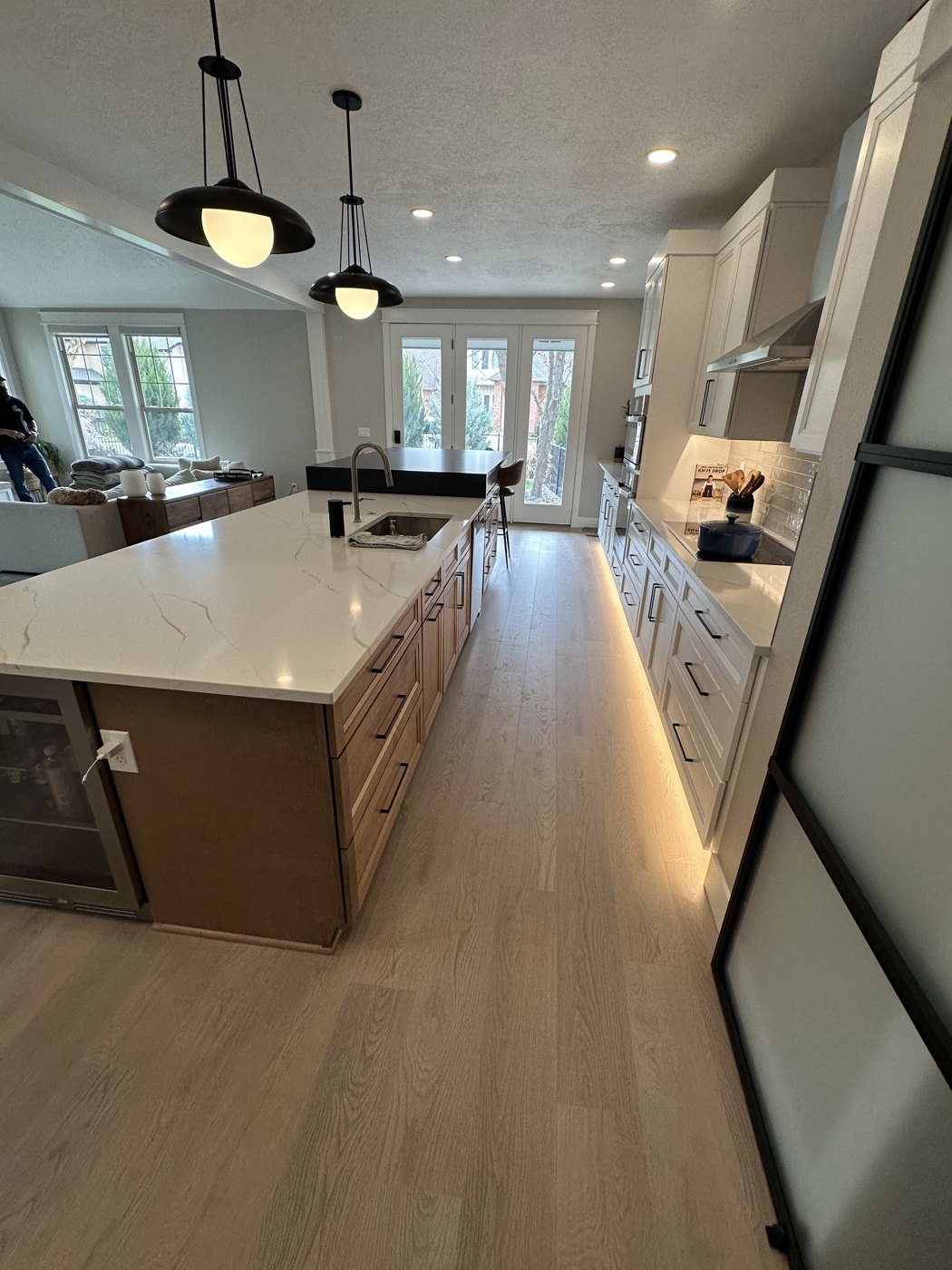 Remodeled kitchen with white cabinets and wood-look flooring
